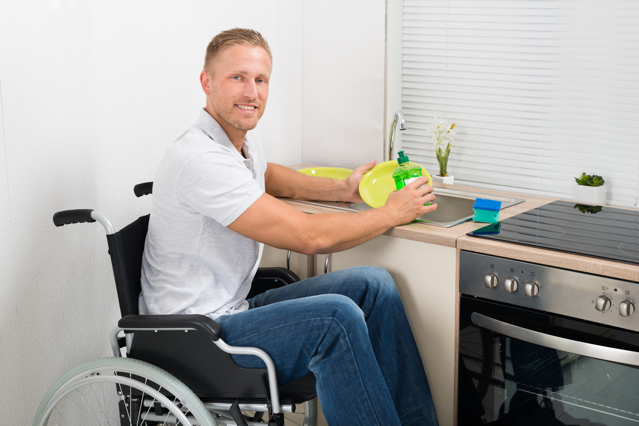 Disabled Man On Wheelchair Washing Dishes